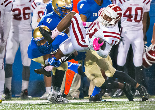 Hillgrove's Tavion Walker (11) is spun in the air as he is tackled by McEachern's Bryce Sims (18) on Friday, November 6, 2015. 