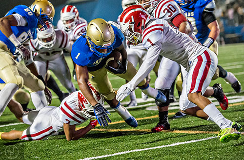 McEachern's Sam Jackson (center) brings the ball down to the five yard line as he is tackled by Hillgrove's Jalen Phelps (right) and Jeremiah Bridges (3) on Friday, November 6, 2015. 