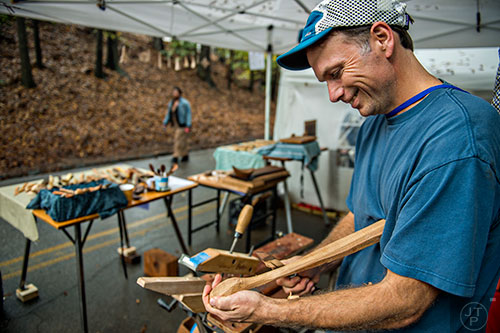 Jay Hallinan carves a wooden spoon using a knife in his booth at the Chastain Park Arts Festival on Saturday, November 7, 2015. 