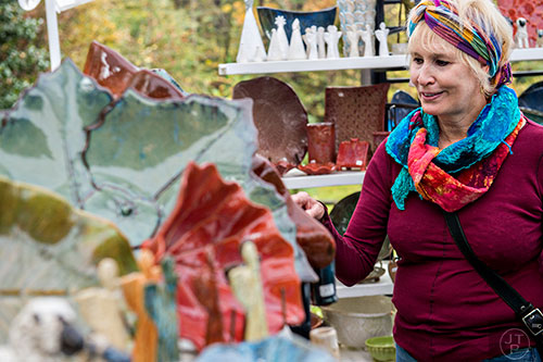 Jackie Gunther looks at pottery designed by Caron Baker Wike during the Chastain Park Arts Festival on Saturday, November 7, 2015. 