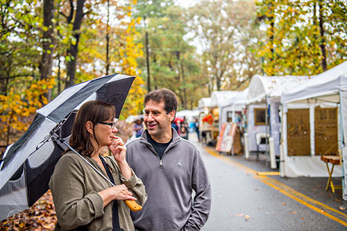 Jackie Bugica (left) and her husband Joe discuss a piece of art during the Chastain Park Arts Festival on Saturday, November 7, 2015. 