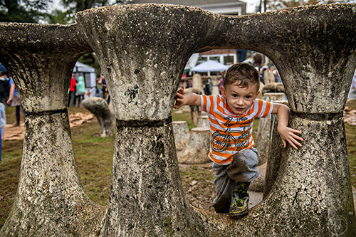 Isaac Hurley (right) climbs on the stone artwork at Cabbagetown Park during the Cabbagetown Chomp & Stomp in Atlanta on Saturday, November 7, 2015. 