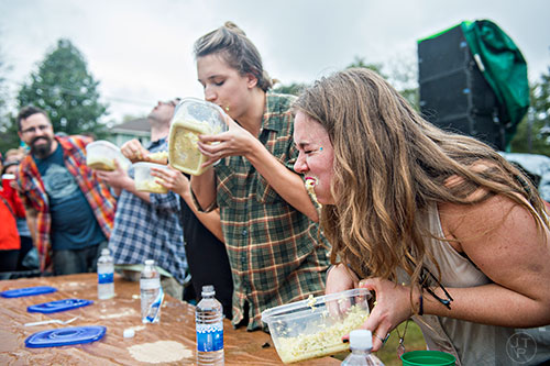 Cole slaw drips from Emily Ward's (right) mouth as she competes in the cole slaw eating contest during the Cabbagetown Chomp & Stomp in Atlanta on Saturday, November 7, 2015. 