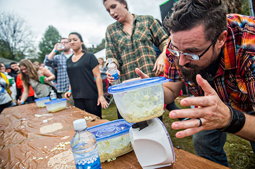 Josh Minter weighs the remaining cole slaw to try and determine the winner of the cole slaw eating contest during the Cabbagetown Chomp & Stomp in Atlanta on Saturday, November 7, 2015. 