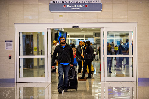 Praveen Rajendran exits customs in the international terminal of the Hartfield Jackson International Airport in Atlanta on Saturday, November 14, 2015. Rajendran was returning from Paris, France.  