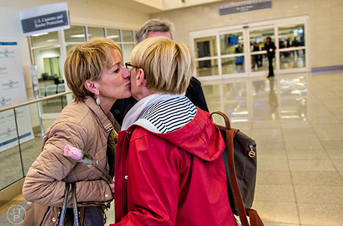 Christelle Orzan (left) kisses her mother Odile Robiolle on the cheek as her parents exit customs in the international terminal of the Hartfield Jackson International Airport in Atlanta on Saturday, November 14, 2015. The couple is visiting their daughter and her husband for Thanksgiving after flying in from Paris, France.  