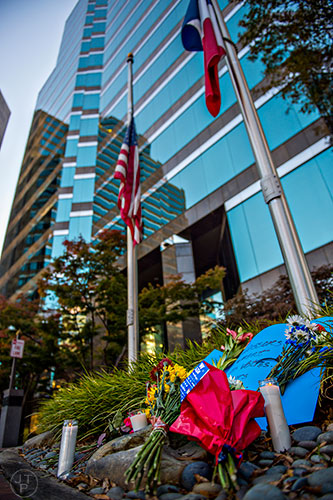 A small memorial including flowers, candles, signs and photographs sit outside of the Consulate General of France's offices at the Buckhead Tower at Lenox Square in Atlanta on Saturday, November 14, 2015.   