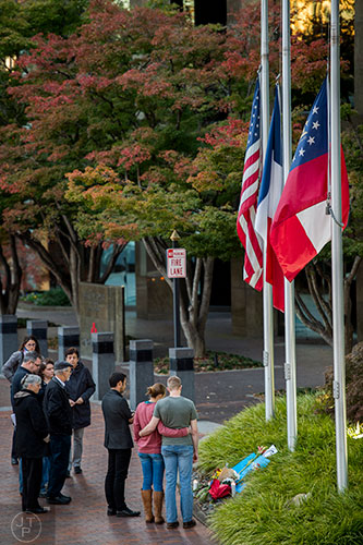 Around a dozen people congregate outside of the Consulate General of France's offices at the Buckhead Tower at Lenox Square in Atlanta for a vigil on Saturday, November 14, 2015. 
