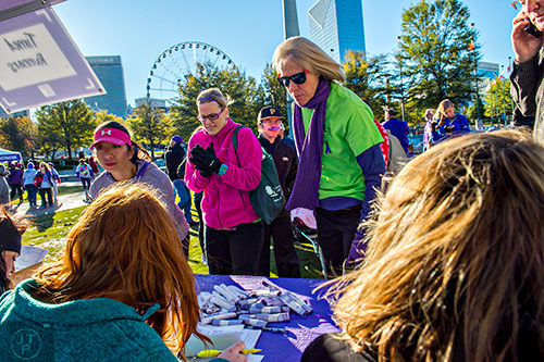 Laurie Plath (center) and Kristen Nigro register to walk in the PurpleStride Atlanta 5k at Centennial Olympic Park in Atlanta on Saturday, November 14, 2015. 