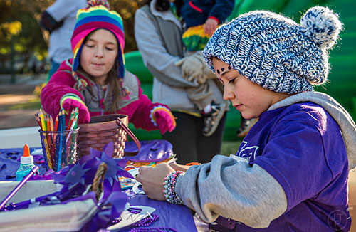 Kaycie Smith (right) and Allie Rainbow decorate masks before the start of the PurpleStride Atlanta 5k at Centennial Olympic Park in Atlanta on Saturday, November 14, 2015. 