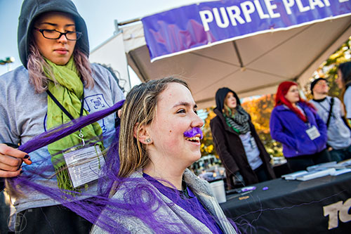 Jennifer Nealer (center) has Krysta Meyers put purple extensions in her hair before the start of the PurpleStride Atlanta 5k at Centennial Olympic Park in Atlanta on Saturday, November 14, 2015. 