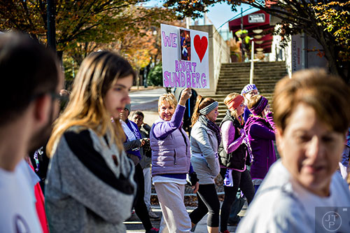 Becca Sadri (center) holds up a sign in memory of Robert Sundberg as she walks in the PurpleStride Atlanta 5k at Centennial Olympic Park in Atlanta on Saturday, November 14, 2015. 