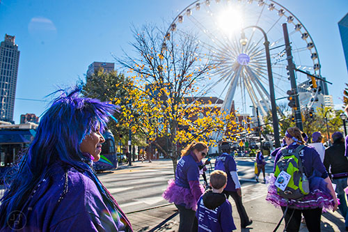 Loyda Zimot (left) passes the Sky Wheel as she walks in the PurpleStride Atlanta 5k at Centennial Olympic Park in Atlanta on Saturday, November 14, 2015. 