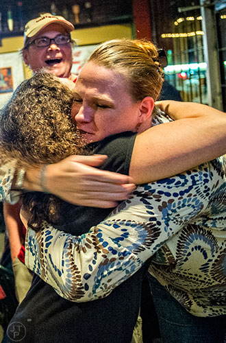 Suzy Baerwalde (right) hugs Marjorie Snook as poll results come in during the Dekalb Strong viewing party at Melton's app & tap on Tuesday.