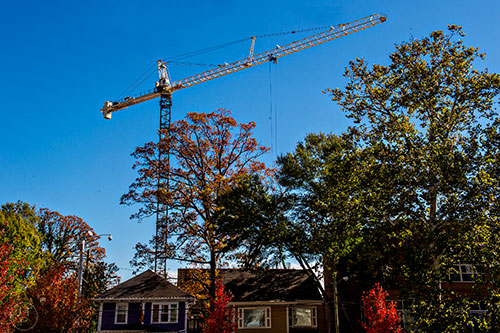 A crane rises above the houses and trees on Juniper St. in Atlanta.