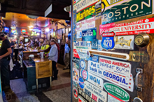 The walls and doors of Manuel's Tavern in Atlanta are covered with memorabilia, bumper stickers, photos and art.