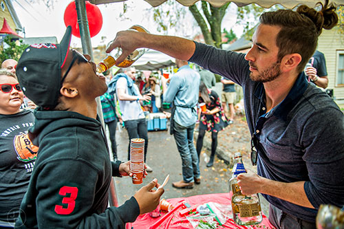 Derek Little (right) gives Russell Owens a shot of tequila during the Cabbagetown Chomp & Stomp in Atlanta on Saturday, November 7, 2015.