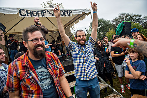 Riley Perszyk (center) throws his hands into the air after being named the winner of the cole slaw eating contest during the Cabbagetown Chomp & Stomp in Atlanta on Saturday, November 7, 2015.