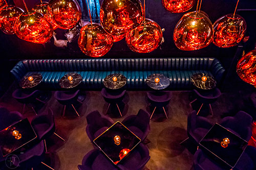 The second floor overlooks the first at Himitsu Lounge in Atlanta showing off the chandeliers that hang above.