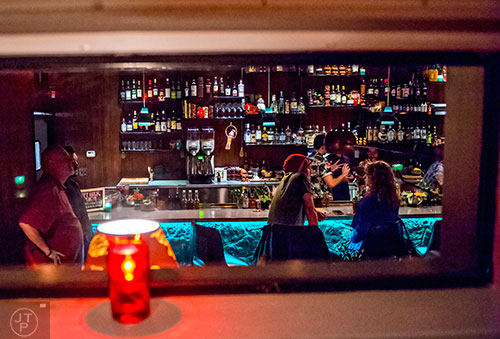 Low windows give a glimpse inside S.O.S. Tiki Bar in Decatur.