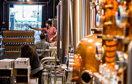 Andrew Quigley (center) places empty bottles on a pallet during bottling day at Old Fourth Distillery in Atlanta.