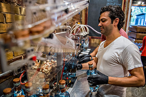 Gabe Pilato works the capping machine during bottling day at Old Fourth Distillery in Atlanta.