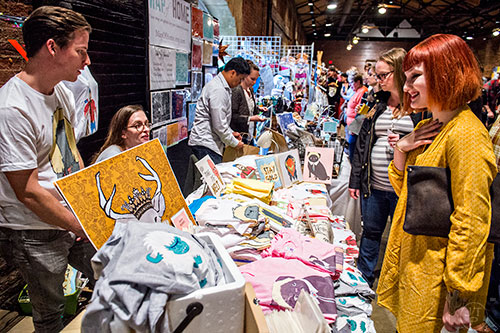 Abbie Stein (right) talks with Lucy Ricketts and Brandon Steffens during the Indie Craft Experience's Holiday Shopping Spectacular at the Georgia Freight Depot in Atlanta on Saturday, November 21, 2015. 