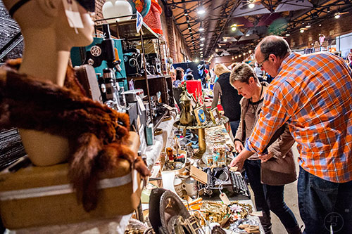 Bob Hartwell (right) and Joy James look at one of the artist booths during the Indie Craft Experience's Holiday Shopping Spectacular at the Georgia Freight Depot in Atlanta on Saturday, November 21, 2015. 