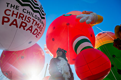 Candace Cashbaugh holds onto a guide wire for one of the giant balloons before the start of the 2015 Children's Christmas Parade in Atlanta on Saturday, December 5, 2015. 