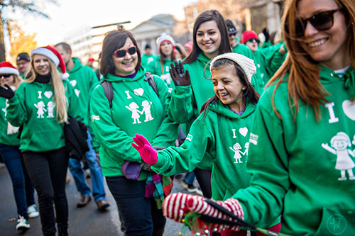 Olivia Harvey (center) waves to the crowd as she marches with her family and other Children's patients during the 2015 Children's Christmas Parade in Atlanta on Saturday, December 5, 2015.