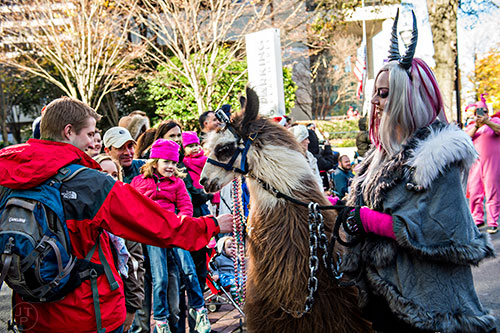 Mike Farnsworth (left) reaches out to pet Tonka as Jen Belgard leads him past during the 2015 Children's Christmas Parade in Atlanta on Saturday, December 5, 2015. 