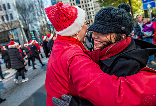 Tallulah Dropkin (right) hugs Carolyn Benkowitz as she passes by during the 2015 Children's Christmas Parade in Atlanta on Saturday, December 5, 2015. 