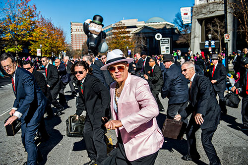 Marty Mercer (center) leads the Briefcase Brigade down Peachtree St. during the 2015 Children's Christmas Parade in Atlanta on Saturday, December 5, 2015. 