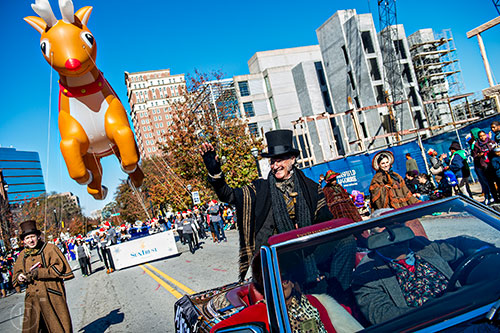 David DeVries (center), who plays Scrooge for the Alliance Theatre, waves to the crowd during the 2015 Children's Christmas Parade in Atlanta on Saturday, December 5, 2015. 