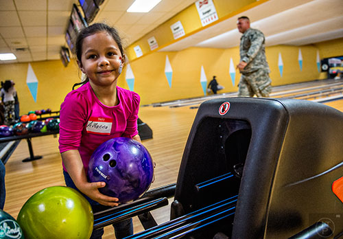 Arianna Martinez (left) grabs her bowling ball during the Atlanta Braves' Military Basebowl event at Midtown Bowl in Atlanta on Saturday, December 5, 2015.