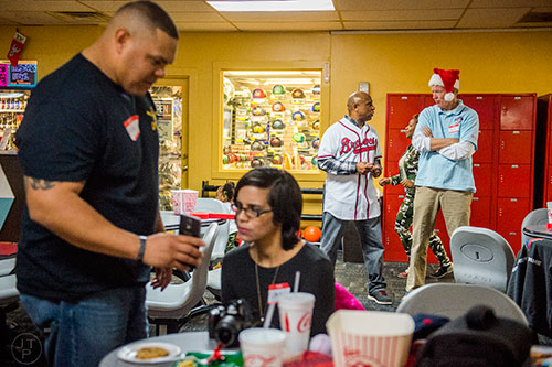Terry Pendleton (center) talks with Dave Badertscher as Ricky Martinez (left) shows his wife Ana his phone during the Atlanta Braves' Military Basebowl event at Midtown Bowl in Atlanta on Saturday, December 5, 2015. 