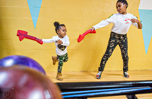 Jazell Reuben (left) dances with her sister Dimya during the Atlanta Braves' Military Basebowl event at Midtown Bowl in Atlanta on Saturday, December 5, 2015.