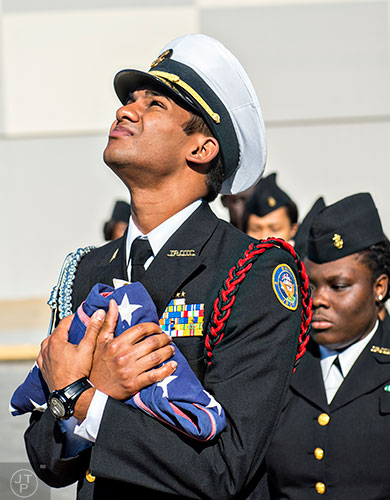Lachman Dukharan (center) holds onto the American flag as he looks up at the newly installed flag pole before the start of the 74th anniversary of Pearl Harbor ceremony at the DeKalb County School District Administrative and Instructional Complex in Stone Mountain on Monday, December 7, 2015. 