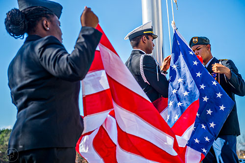 Jordan Bradley (right), Lachman Dukharan and Destinee Biggs raise the American flag on a newly installed flag pole during the 74th anniversary of Pearl Harbor ceremony at the DeKalb County School District Administrative and Instructional Complex in Stone Mountain on Monday, December 7, 2015.  