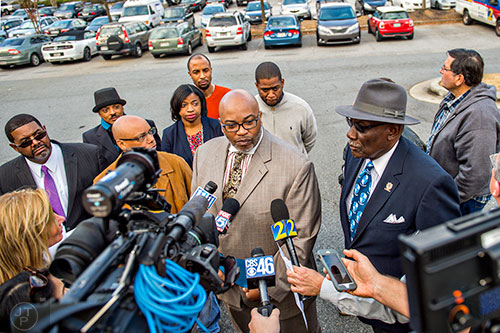 Former Atlanta councilman Derrick Boazman (center) is flanked by Ben Williams (right) Brian Baker (back right), his lawyer Kim Bandoh (back left) and other community leaders as he calls for the immediate termination of Cobb County Police Officer Maurice Lawson outside of the Cobb County Police Department Headquarters in Marietta on Thursday, December 10, 2015. 