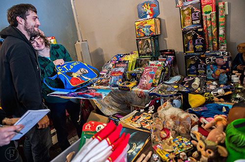 Mike Stevens (left) hugs Melissa Brewer as they try to make the tough decisions on which E.T. collectables to purchase during the Bazaar on the Beltline at The Hanger off of the Eastside Trail in Atlanta on Saturday, December 12, 2015. 