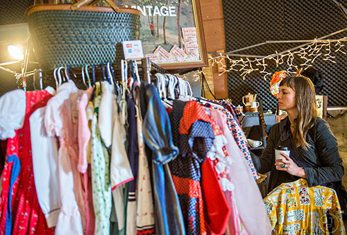 Emma Exum looks through a rack of vintage clothing during the Bazaar on the Beltline at The Hanger off of the Eastside Trail in Atlanta on Saturday, December 12, 2015. 