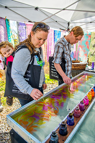 Liam Spanjer (left) looks as his mother Missy and his uncle Chris Willingham design a silk scarf during the Bazaar on the Beltline at The Hanger off of the Eastside Trail in Atlanta on Saturday, December 12, 2015. 