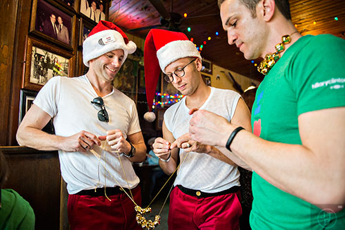 Andy Markowski-McNeil (left), his husband Kurt and Jeffrey Wolff string jingle bells together before the start of the annual Atlanta Santa Speedo Run at Manuel's Tavern in Atlanta on Saturday, December 12, 2015. 