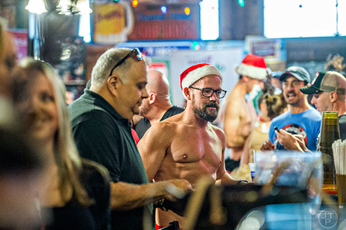 Dressed as Santa, Scott Bartruff orders drinks from the bar before the start of the annual Atlanta Santa Speedo Run at Manuel's Tavern in Atlanta on Saturday, December 12, 2015. 
