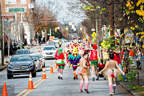 Dressed as reindeer, Kellie Reese (center) turns to Sarah Cloud during the annual Atlanta Santa Speedo Run at Manuel's Tavern in Atlanta on Saturday, December 12, 2015. 