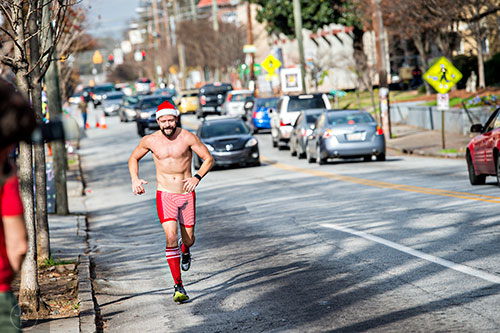 Dressed as Santa, Scott Bartruff runs up North Highland Ave. during the annual Atlanta Santa Speedo Run at Manuel's Tavern in Atlanta on Saturday, December 12, 2015. 