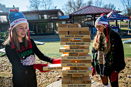 Clare DeBerry (left) and Cayman Szegda play a game of jenga before the start of the Ugly Sweater Run at Piedmont Park in Atlanta on Saturday, December 19, 2015. 