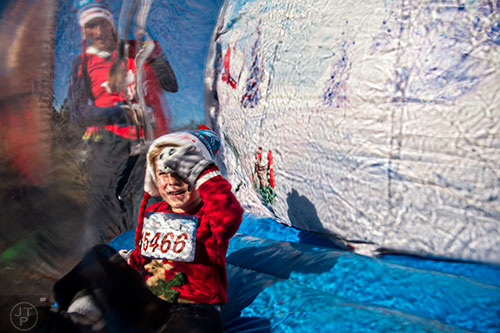 Brendan Woehler plays in a giant snow globe before the start of the Ugly Sweater Run at Piedmont Park in Atlanta on Saturday, December 19, 2015. 