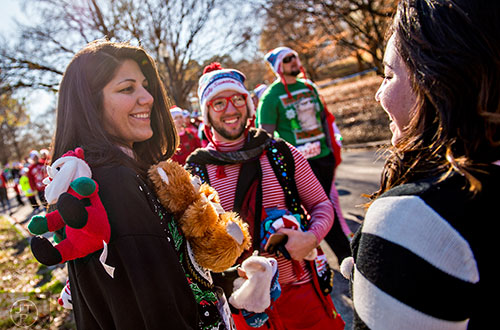 Mary Fernandez (left) talks with Christian Theis and Maria Vega before the start of the Ugly Sweater Run at Piedmont Park in Atlanta on Saturday, December 19, 2015. 